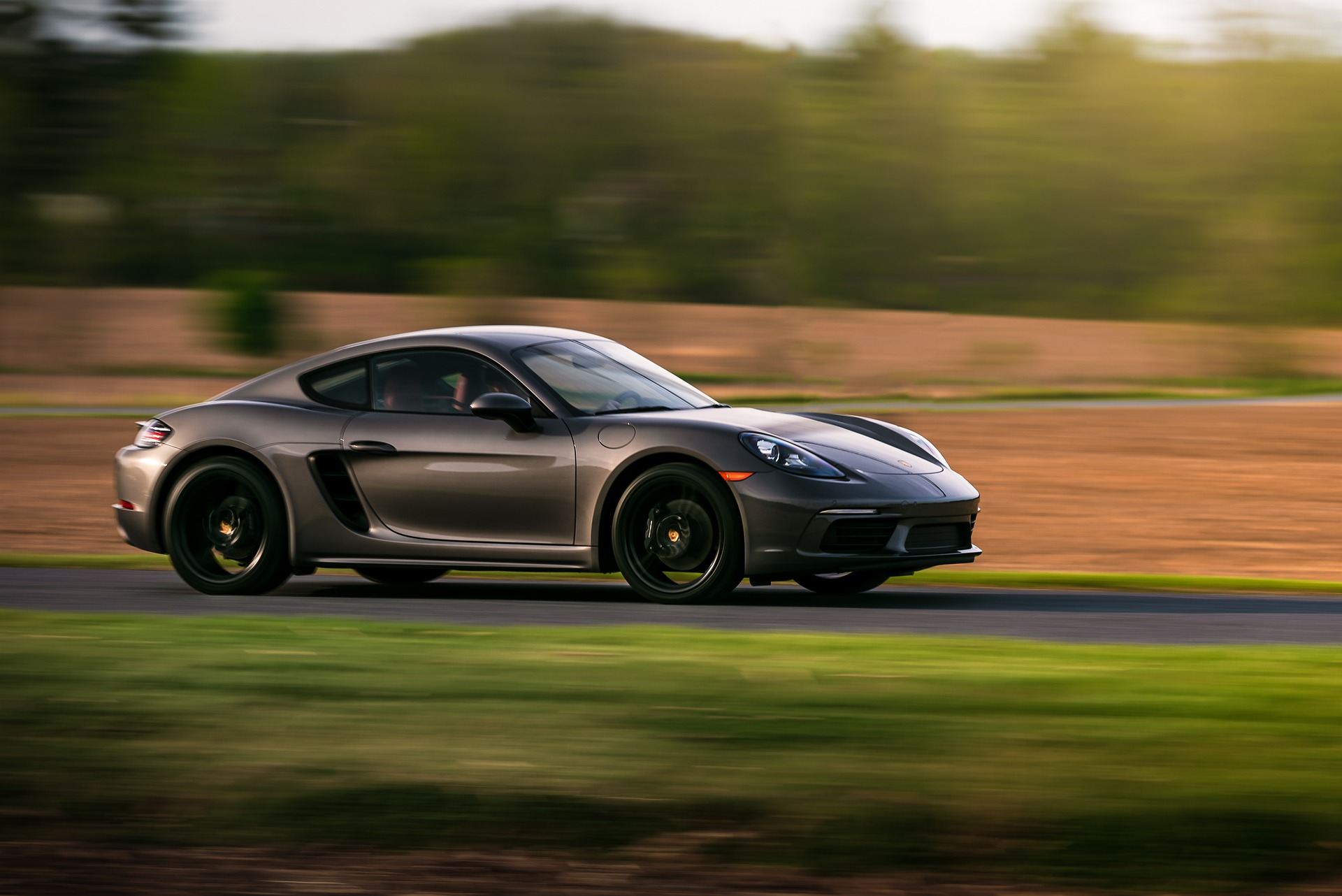 Schwarzer Porsche Youngtimer bei hoher Geschwindigkeit in der Landschaft